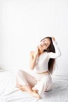 woman in white cozy clothes sitting on the floor with eyes closed photo