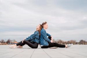 couple sitting back to back in the street spending time together photo