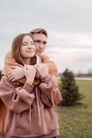 Young loving couple embracing each other outdoors in the park photo