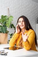 Jardinero mujer trabajando en tableta digital y llamando por teléfono foto