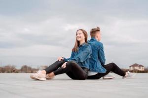 pareja sentada espalda con espalda en la calle pasando tiempo juntos foto