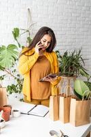 Jardinero mujer trabajando en tableta digital y haciendo una llamada foto