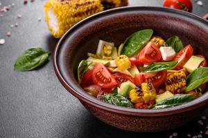 Delicious fresh salad with tomatoes, avocado, cheese and grilled corn photo