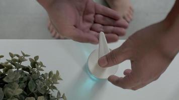 un homme se nettoie les mains et les doigts avec un gel hydroalcoolique.