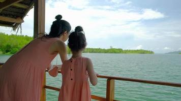 turistas asiáticos madre e hija vestidas del mismo color en la balsa. video