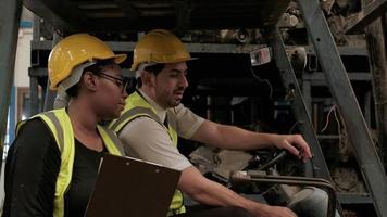 deux ingénieurs d'usine parlant sur le chariot élévateur. video