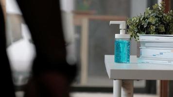 Close-up shot. Casual man is pressing a bottle of alcohol gel, hand sanitizer for health hygiene, and to prevent disease and bacteria such as coronavirus Covid-19 while working at the home office. video