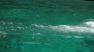 Propeller of long-tail boat, working by diesel engine, fast rotates to move ship, creating a long, white foamy splash in the ocean. By motorboats for transportation and fishing at the Asian sea. video