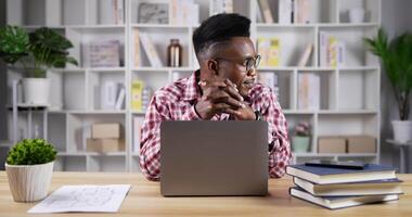 doordachte jonge man aan het werk op laptop thuis video