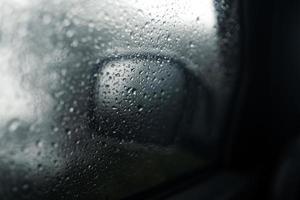 gotas de agua en el parabrisas del coche en un día lluvioso foto