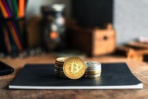 gold bitcoins placed on a wooden desk photo