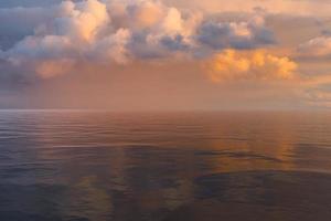 Magical pale pink sky with fluffy colorful clouds photo