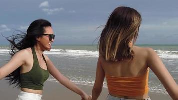 les femmes asiatiques courent et jouent joyeusement à la plage d'été en vacances video