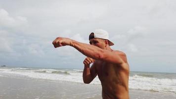 Man doing morning exercise on the beach with boxing video