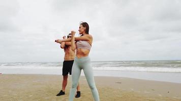 casal fazendo exercícios pela manhã na praia