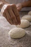 woman hands sprinkling pizza flour close-up photo