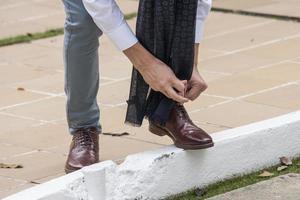 close-up of man tying shoes photo