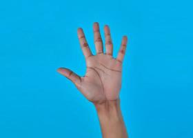 Primer plano de una mano humana que muestra el número cinco 5 con la mano. foto