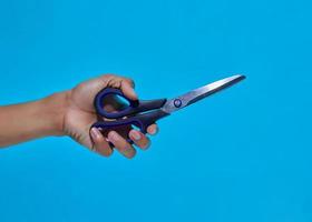 closeup of human hand showing movement will give kitchen scissors. photo