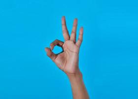 Primer plano de la mano humana que muestra el signo oke o el número 3 con los dedos. foto