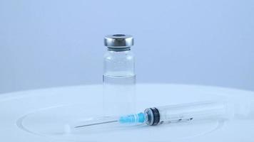 Vacuna contra el coronavirus y jeringa médica sobre fondo blanco.