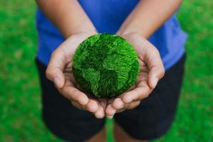 Women hands holding earth on green background photo