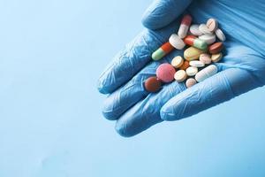 many medical pills on palm of hand with copy space photo