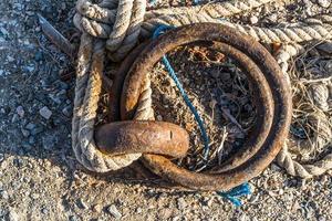 Cadena oxidada y cuerda cerca del muelle foto