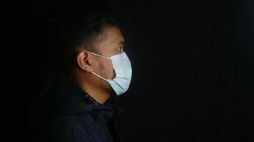 Asian man wearing protective mask isolated over background photo