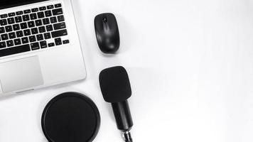 Table top view with notebook, microphone, mouse and keyboard photo