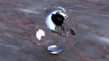 A chrome earth globe rotates on a marble background - Loop video