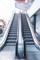 Escaleras mecánicas, subir y bajar escaleras mecánicas en edificio público. foto