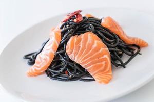 Spicy black spaghetti with salmon - fusion food style photo