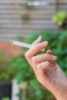 Hand holding cigarette with copy space photo
