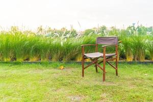 Empty chair on grass in park - with sunflare processing style photo