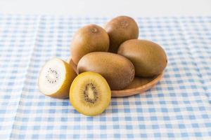 Fresh golden kiwi in wood plate photo