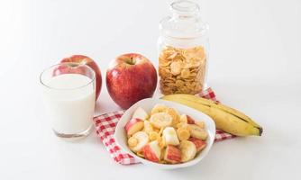 leche, manzana, plátano y copos de maíz para el desayuno foto