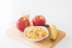 Milk, apple, banana and cornflakes for breakfast photo
