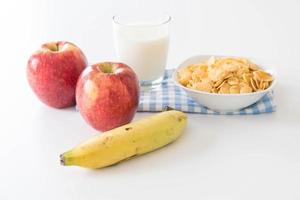 Milk, apple, banana and cornflakes for breakfast photo