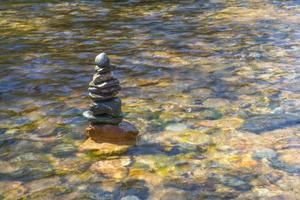 Montón de piedras bellamente apiladas en el río. foto
