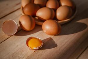 los huevos se ponen en bandejas de madera y tienen huevos rotos. foto