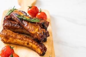 Grilled barbecue ribs pork with rosemary and tomatoes photo