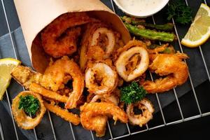 Deep-fried seafood of shrimp and squid with mix vegetables - unhealthy food style photo