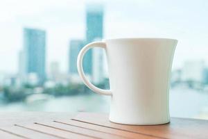 taza de café en la mesa con el horizonte de la ciudad de fondo foto