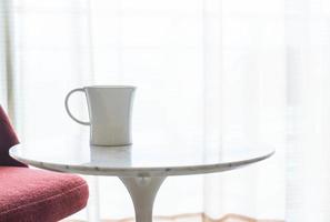 Taza de café con una hermosa decoración de sillas y mesas de lujo en el interior del salón para el fondo - filtro vintage