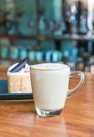 Taza de café con leche caliente en la cafetería. foto