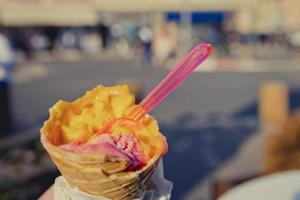 sosteniendo un cono de helado tropical en el momento de la tarde de verano foto