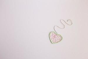 Heart-shaped cloth patch on white background photo
