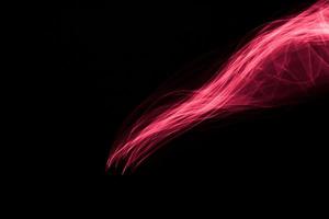 Glowing abstract curved light red and pink lines photo