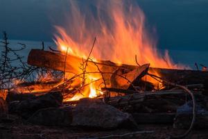 Campfire at twilight on beach photo